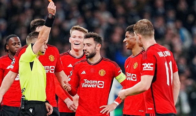Los jugadores del Manchester United rodean al árbitro