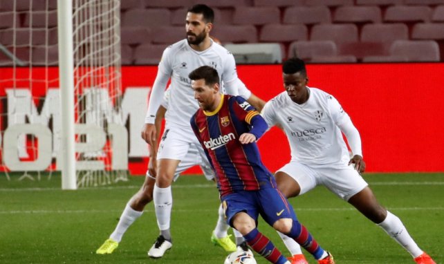 Lionel Messi conduce el cuero ante la presión del Huesca