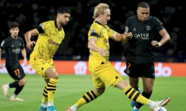 Brandt (Dortmund) y Mbappé (PSG) luchan por un balón