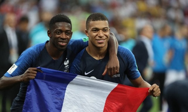 Ousmane Dembélé y Kylian Mbappé sujetando una bandera de Francia